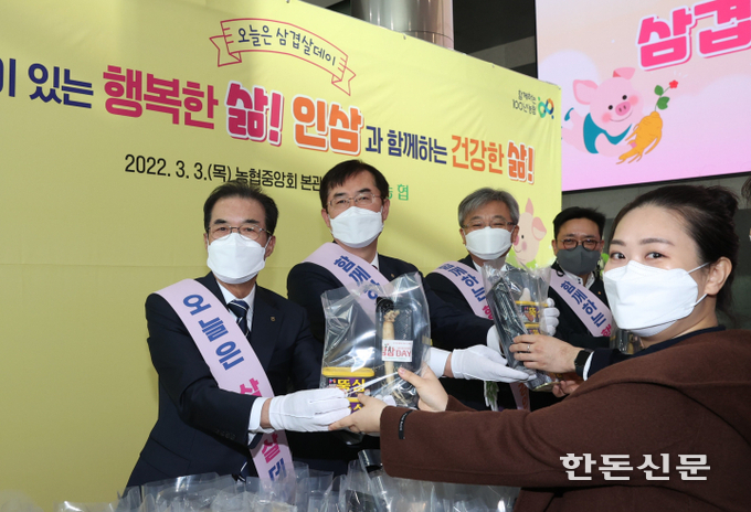 이성희 농협중앙회장(왼쪽)이 삼겹살데이 맞이 나눔행사에서 직원에게 삼삼세트를 나눠주고 있다.
