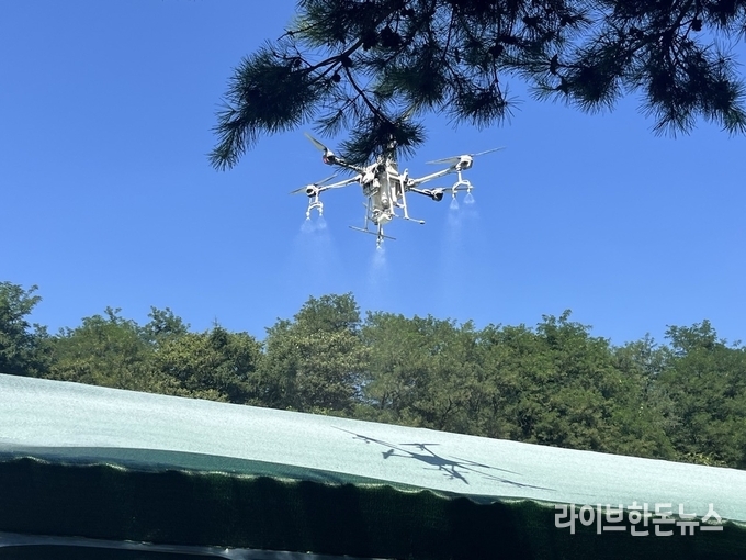 드론으로 축사 지붕에 단열페인트를 뿌리고 있다.